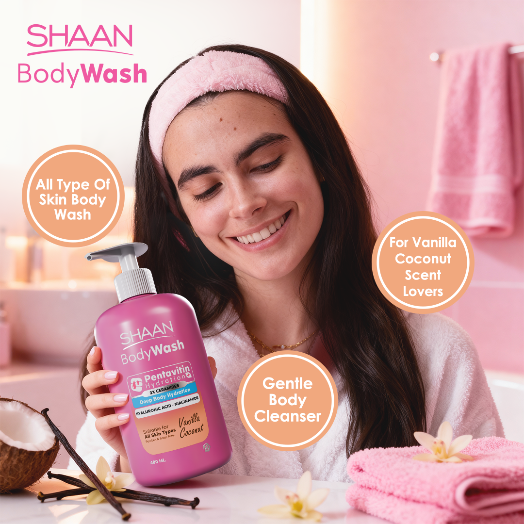 Woman holding a bottle of Shaan Body Wash in a bathroom setting with pink towels and vanilla beans.