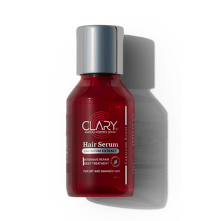 A bottle of Clary Hair Serum with red liquid visible inside the transparent bottle. 