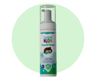 A pump bottle of Superkids Facial Foam cleanser with a label featuring a cartoon character and text indicating it is a gentle facial cleanser for kids.